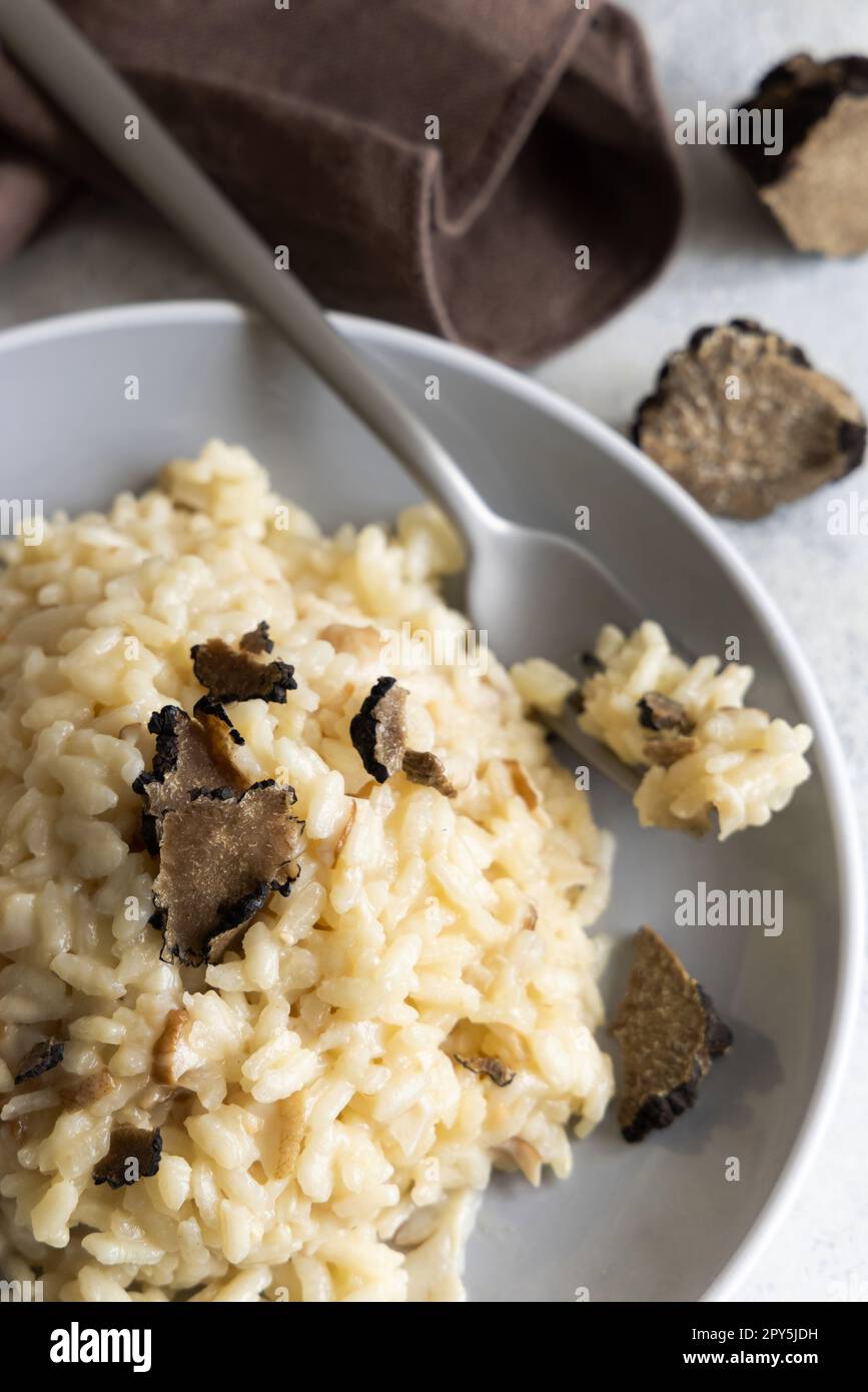 Risotto with porcini mushrooms and black truffles served in a plate top view, gourmet cousine Stock Photo