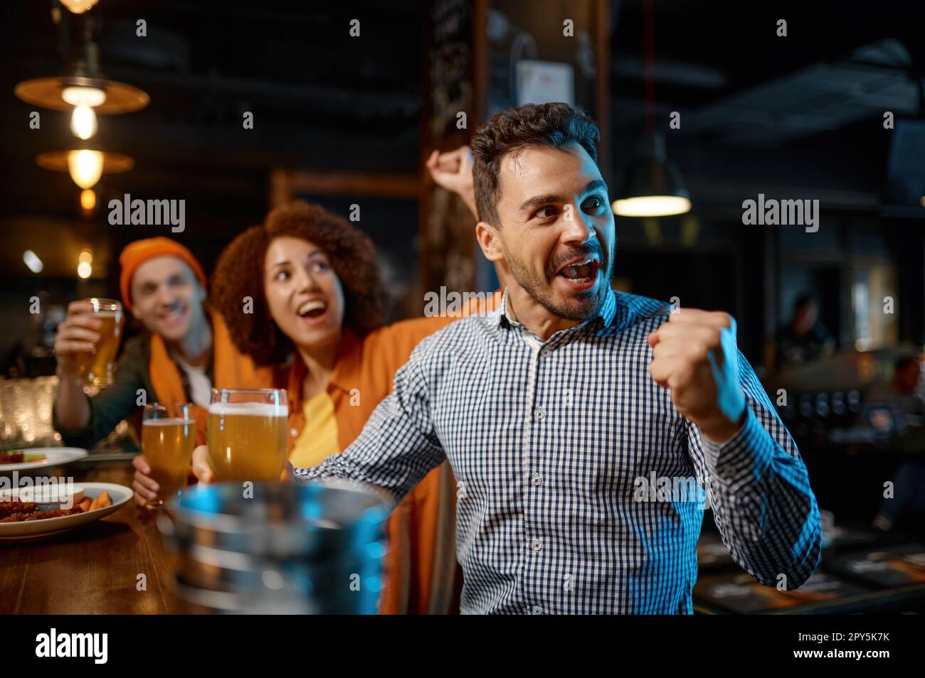 Guys drinking craft beer and watching football game Stock Photo