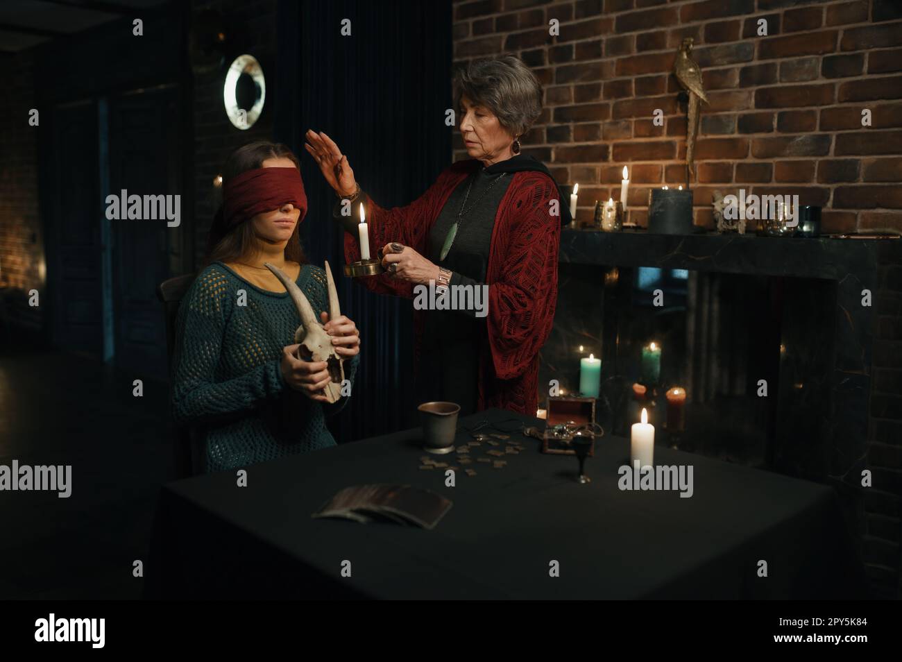 Old mature witch sorceress holding magic ritual for young woman Stock ...