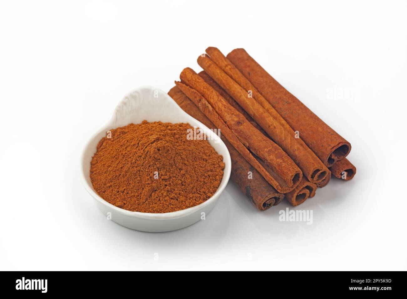 Dried Cinnamon Sticks and Powder isolated over white background Stock Photo