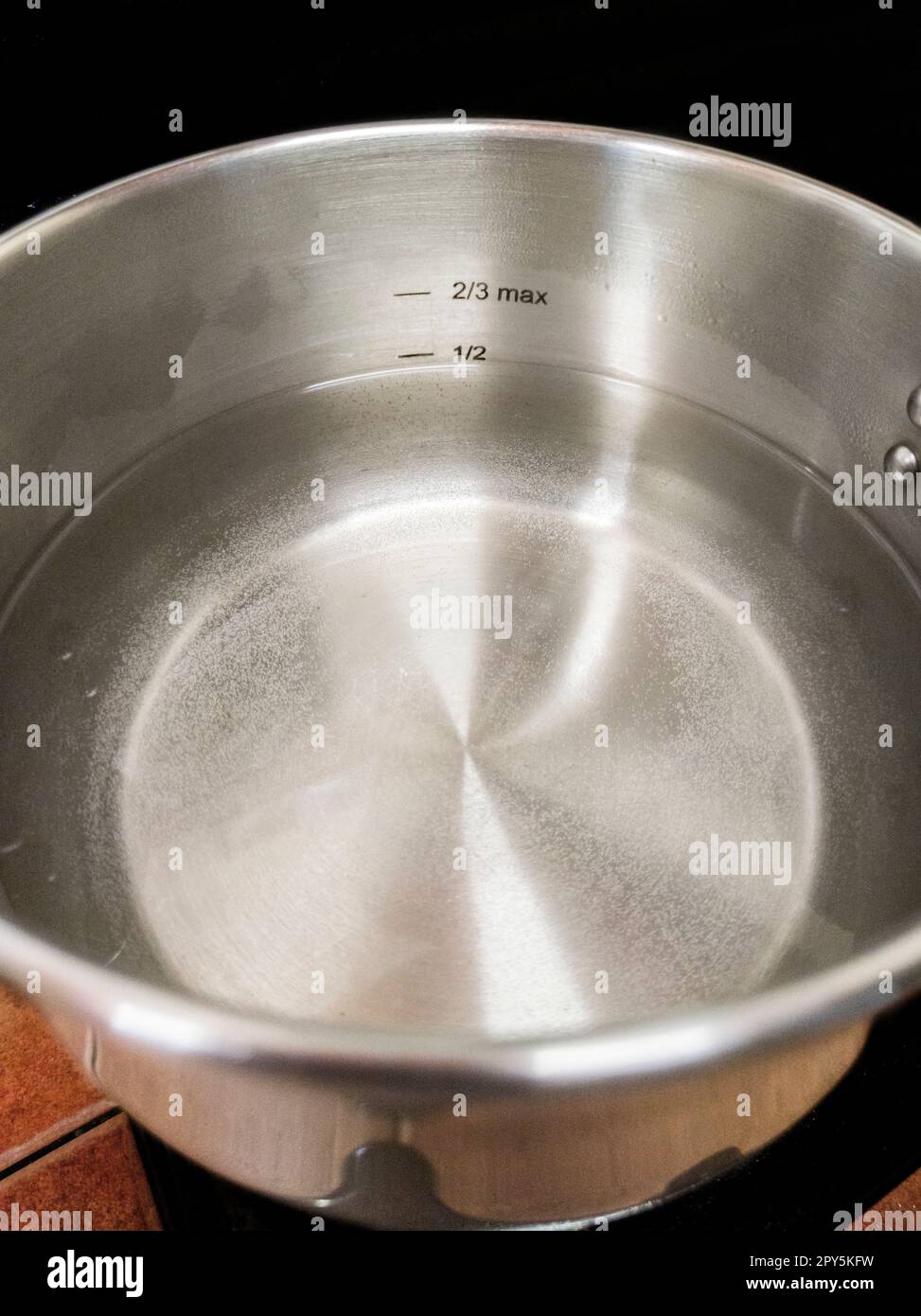 Stainless Steel Pressure Cooker at work. Liquid level markings Stock