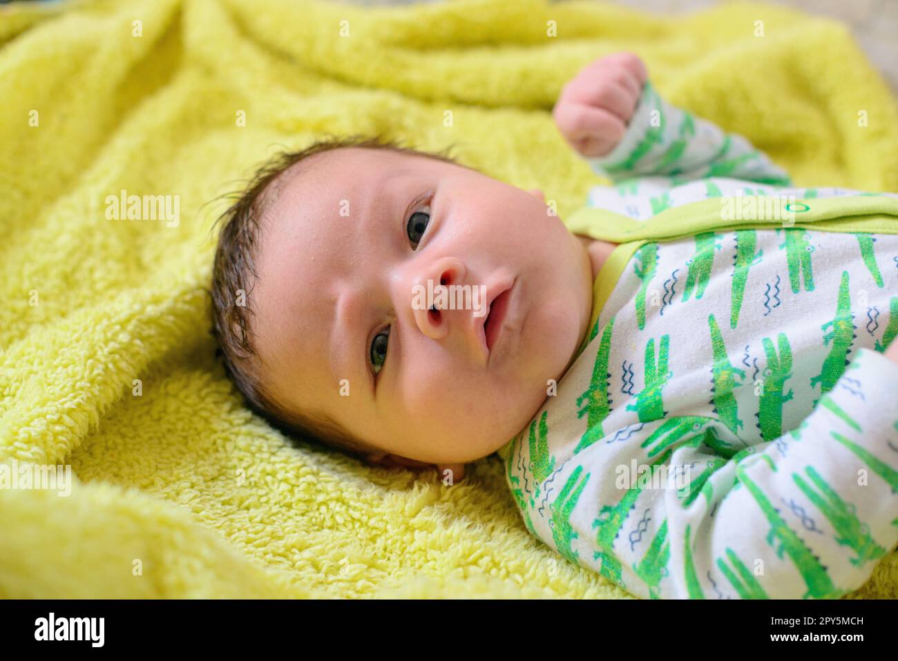 Beautiful newborn white baby lies on a yellow blanket Stock Photo
