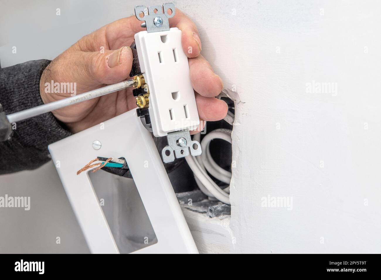Attaching electrical wires to the outlet before installation Stock