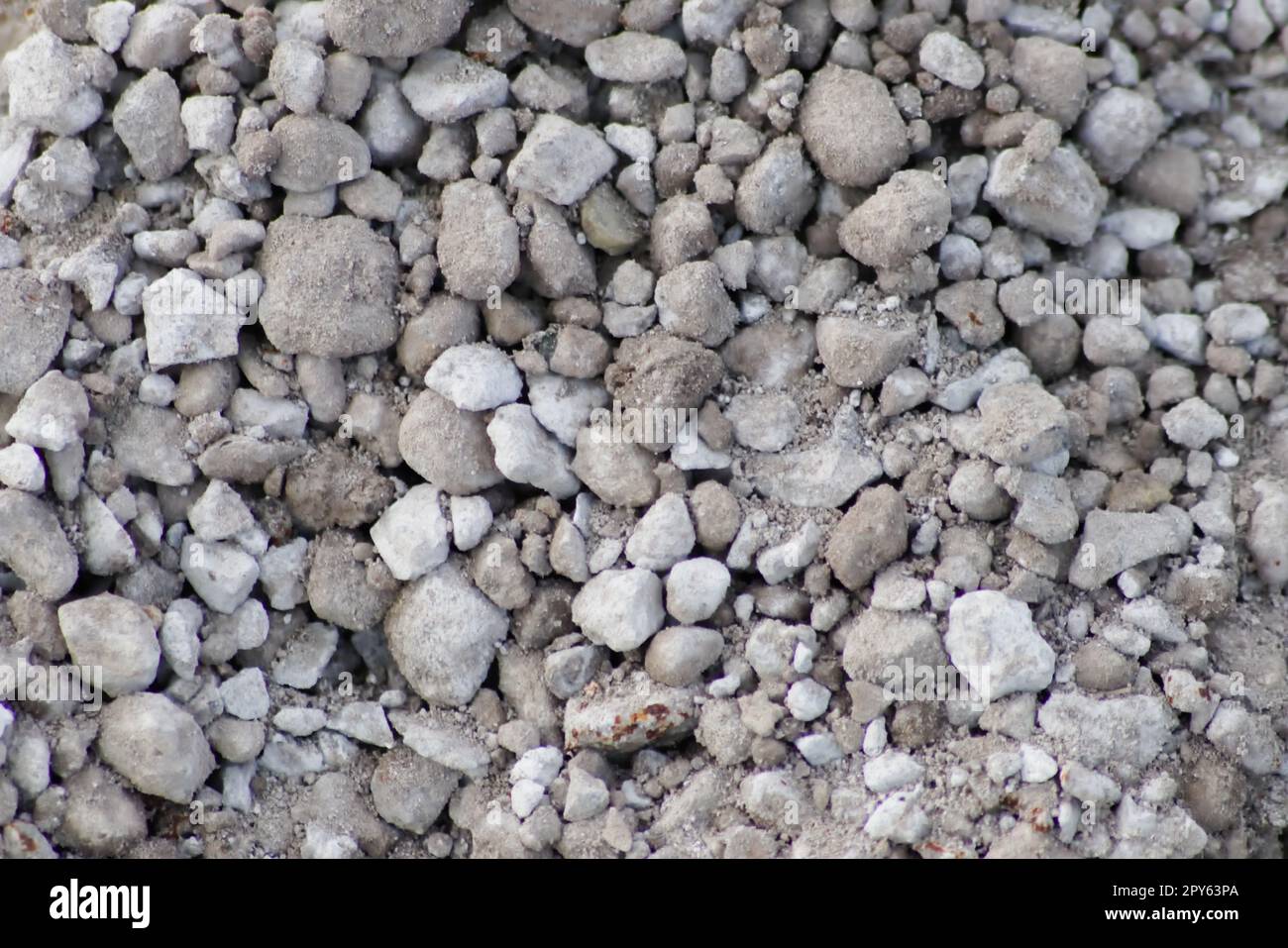 Gray raw rocks and rough stones as natural stones background with crushed and rough material as building material or rocky base for concrete mixture in gray colors as natural stones background Stock Photo