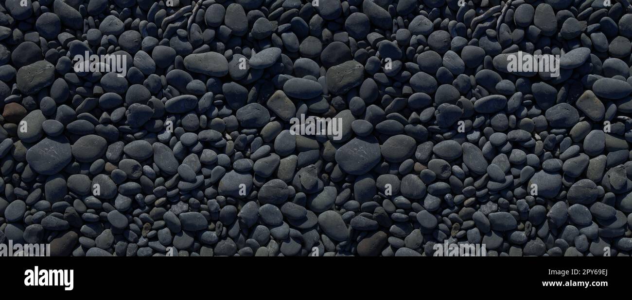 Black pebbles background texture. Banner wallpaper Stock Photo