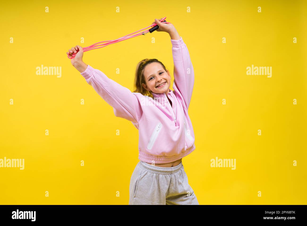 Adorable female child with skipping rope jumping in studio Stock Photo