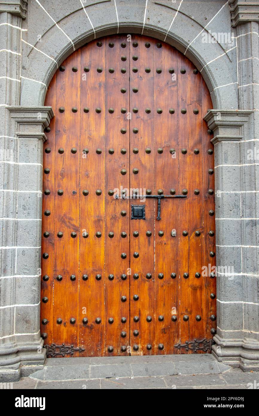 Old massive large wooden door in a stone wall of a church. Stock Photo