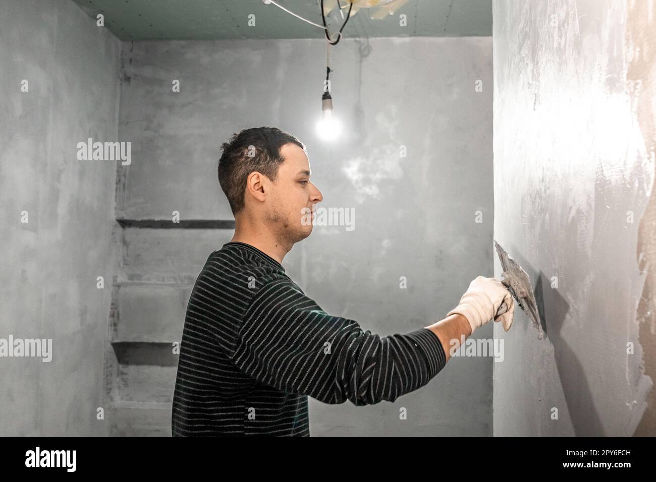 manual adjustment of the wall on the construction site with trowel Stock Photo