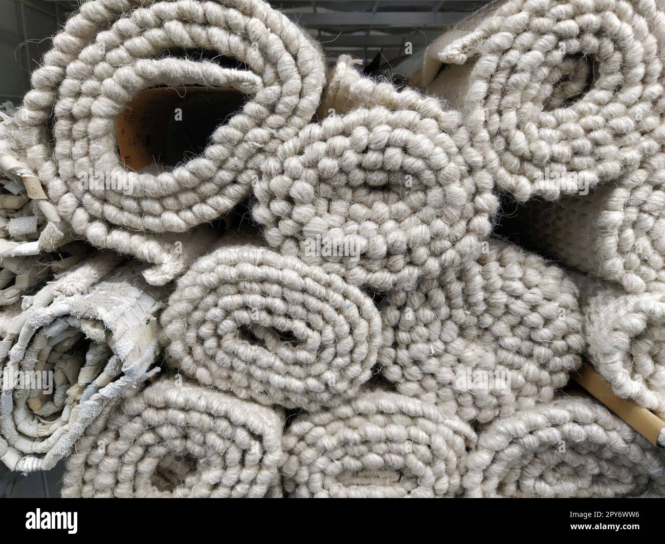 Soft fluffy gray and white rugs folded into skeins, rolls and bundles. An assortment of bedspreads on a store shelf. The blankets are beautifully laid out for sale. Fleecy warm synthetic fabric Stock Photo