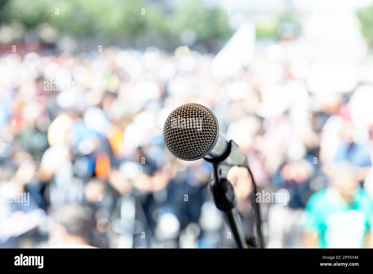Focus on microphone, blurred group of people at mass protest Stock Photo