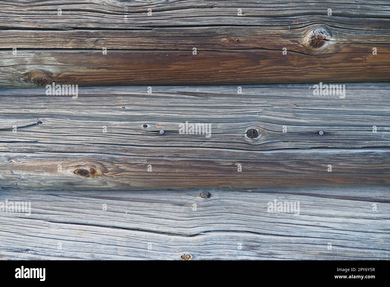 Background horizontal logs. Wooden background from shabby boards and logs. Round lumber assortment. General purpose lumber. Special type of forest products. Knots and branches. Stock Photo