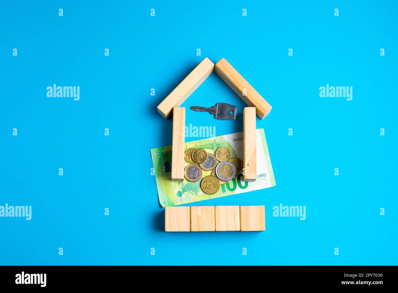 Wooden toy house with keys on blue. Empty space to put text or something else. Stock Photo