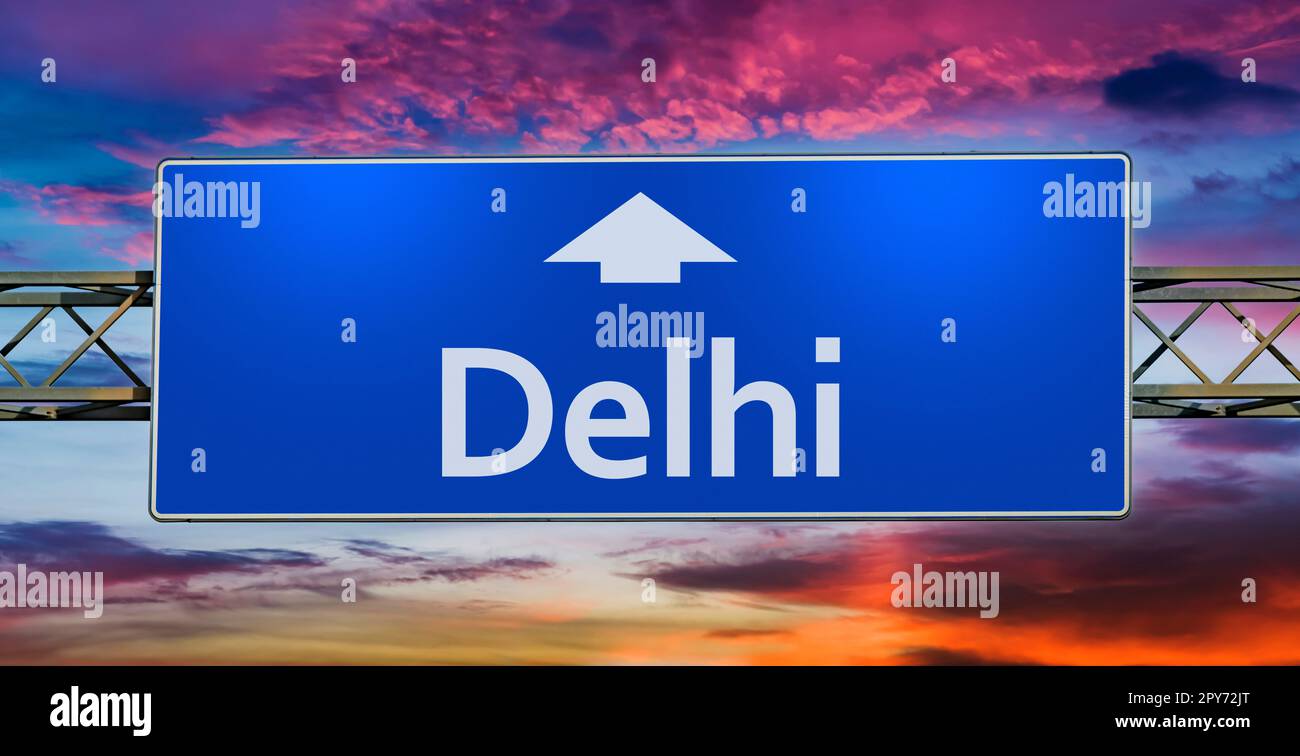 Road sign indicating direction to the city of Delhi Stock Photo