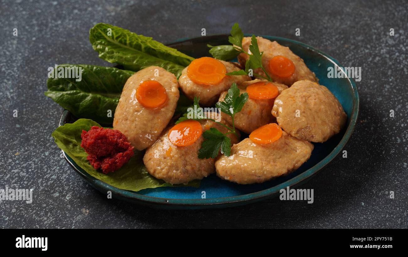 Gefilte fish with carrots, lettuce, horse radish. Passover traditional Jewish food - celebration concept Stock Photo