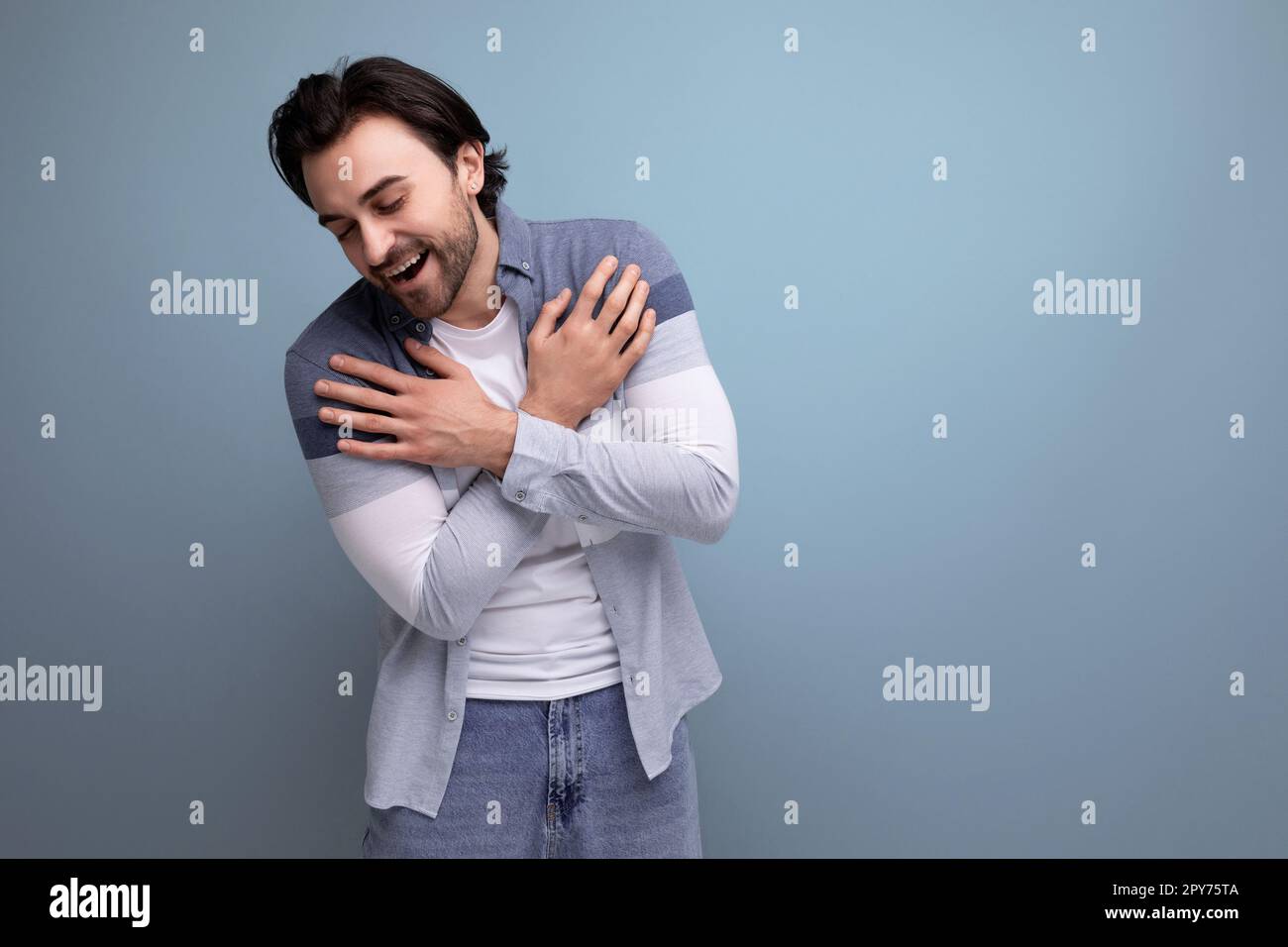 emotional young brutal brunette guy on a studio background for a poster Stock Photo