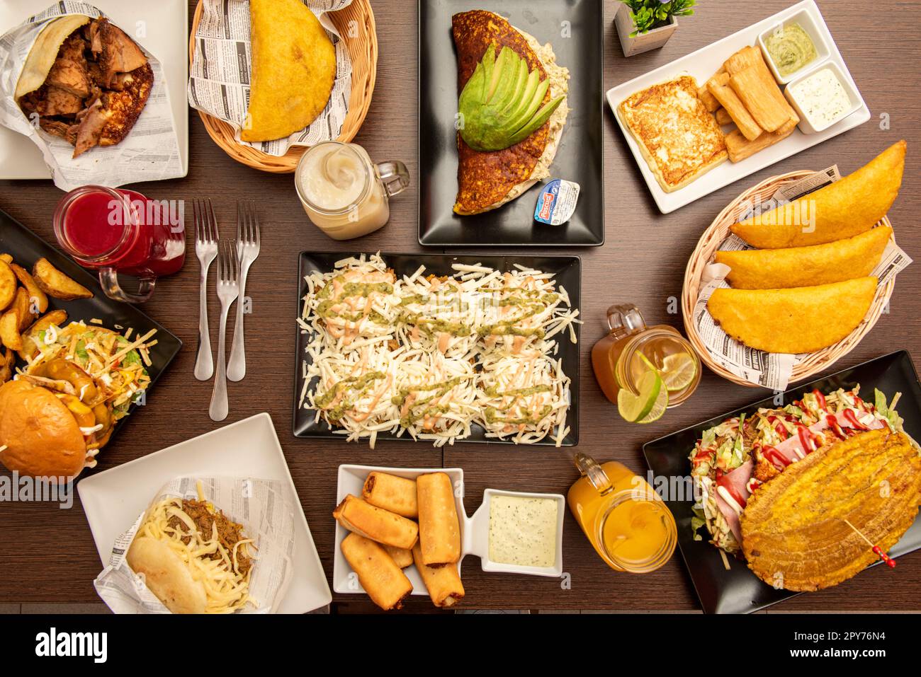 A large sample of typical dishes of Venezuelan gastronomy, with cachapas, corn empanadas, arepas, patacones and other meats Stock Photo