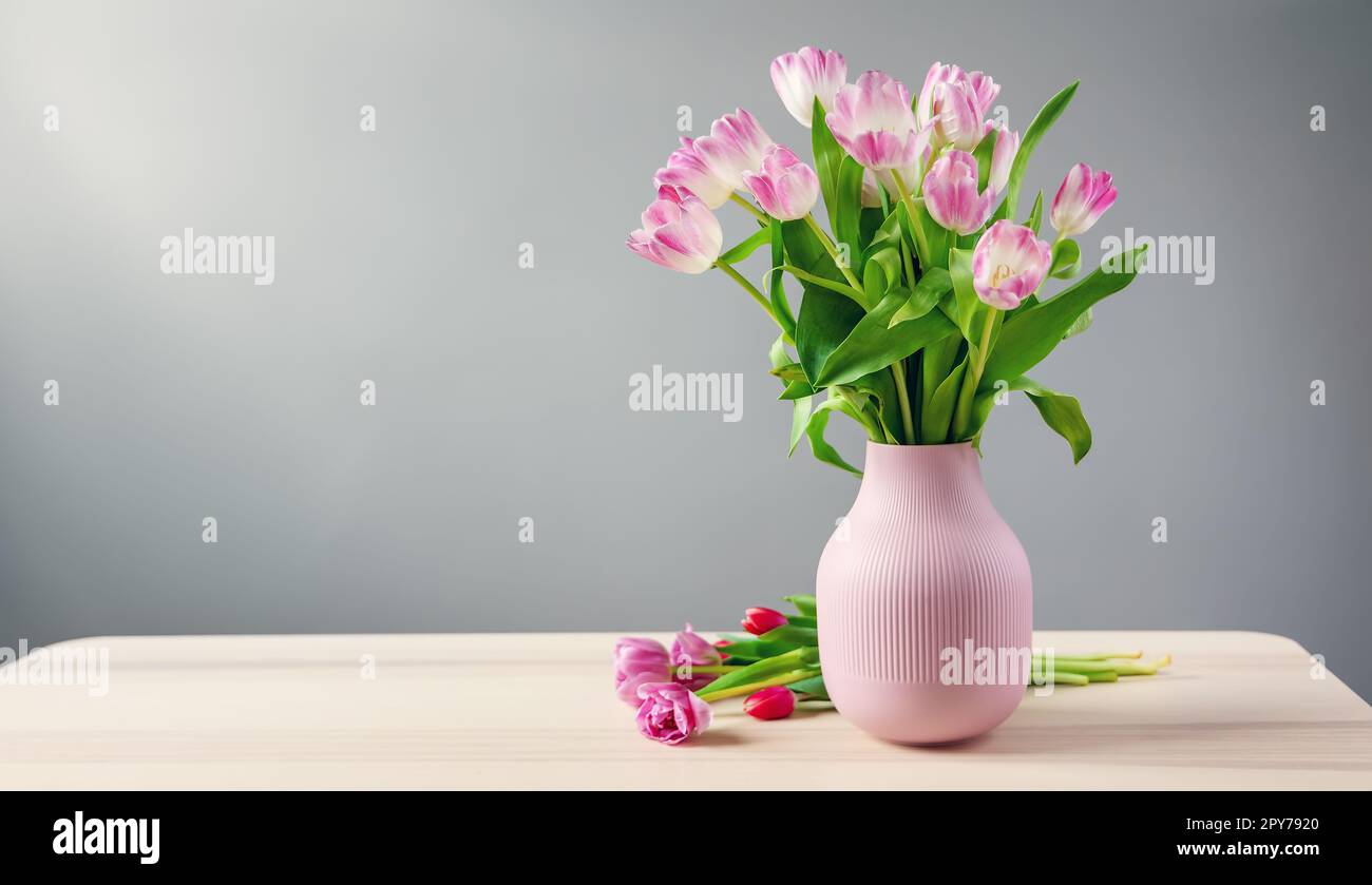 A bunch of tulips in pink vase standing on the wooden table Stock Photo ...