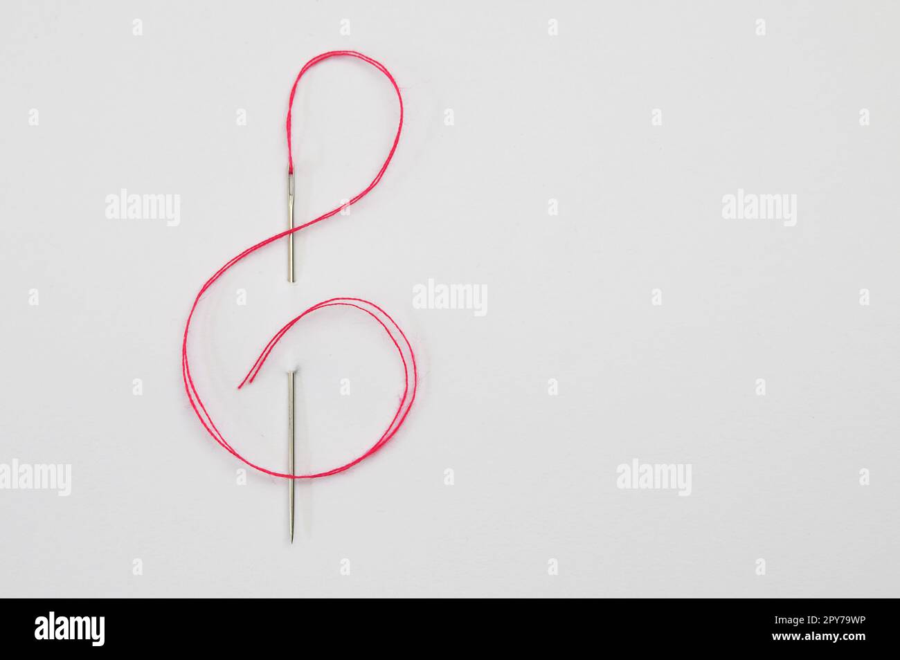 Red cord through the Eye of the Needle In The Form Of A Treble Clef