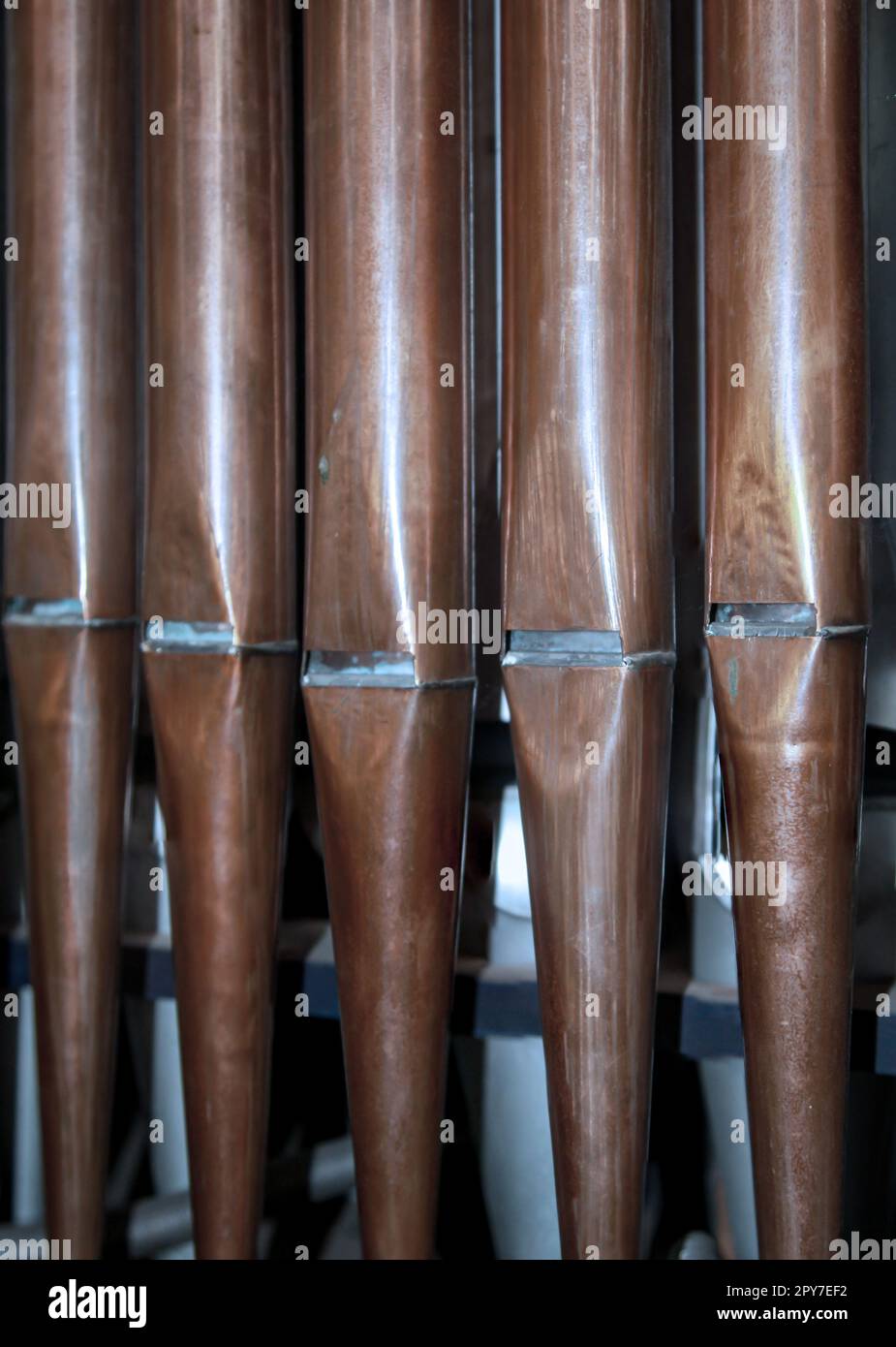 Many organ pipes stand side by side in an organ over a bellows Stock