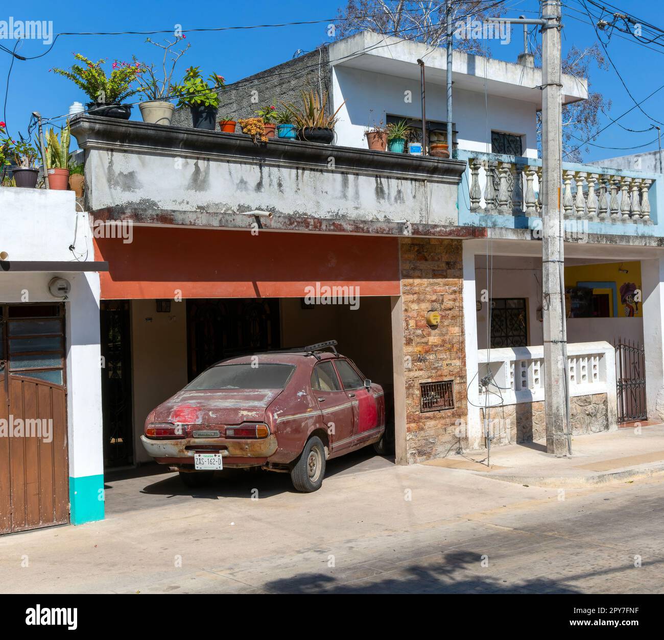 Old Datsun car parked in domestic garage, Vallodolid, Yucatan, Mexico Stock Photo