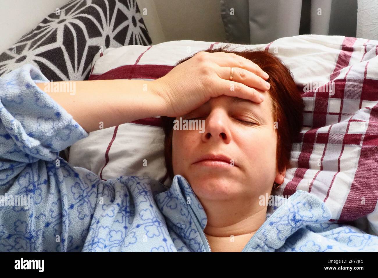 Sick woman in bed. Headache, runny nose and cold. Paleness of the face