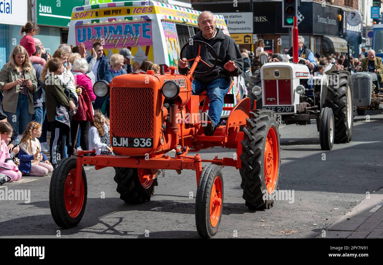 Greeting the crowd during the 2023 May Day Parade of Vintage tractors, Penrith, Cumbria, UK Stock Photo