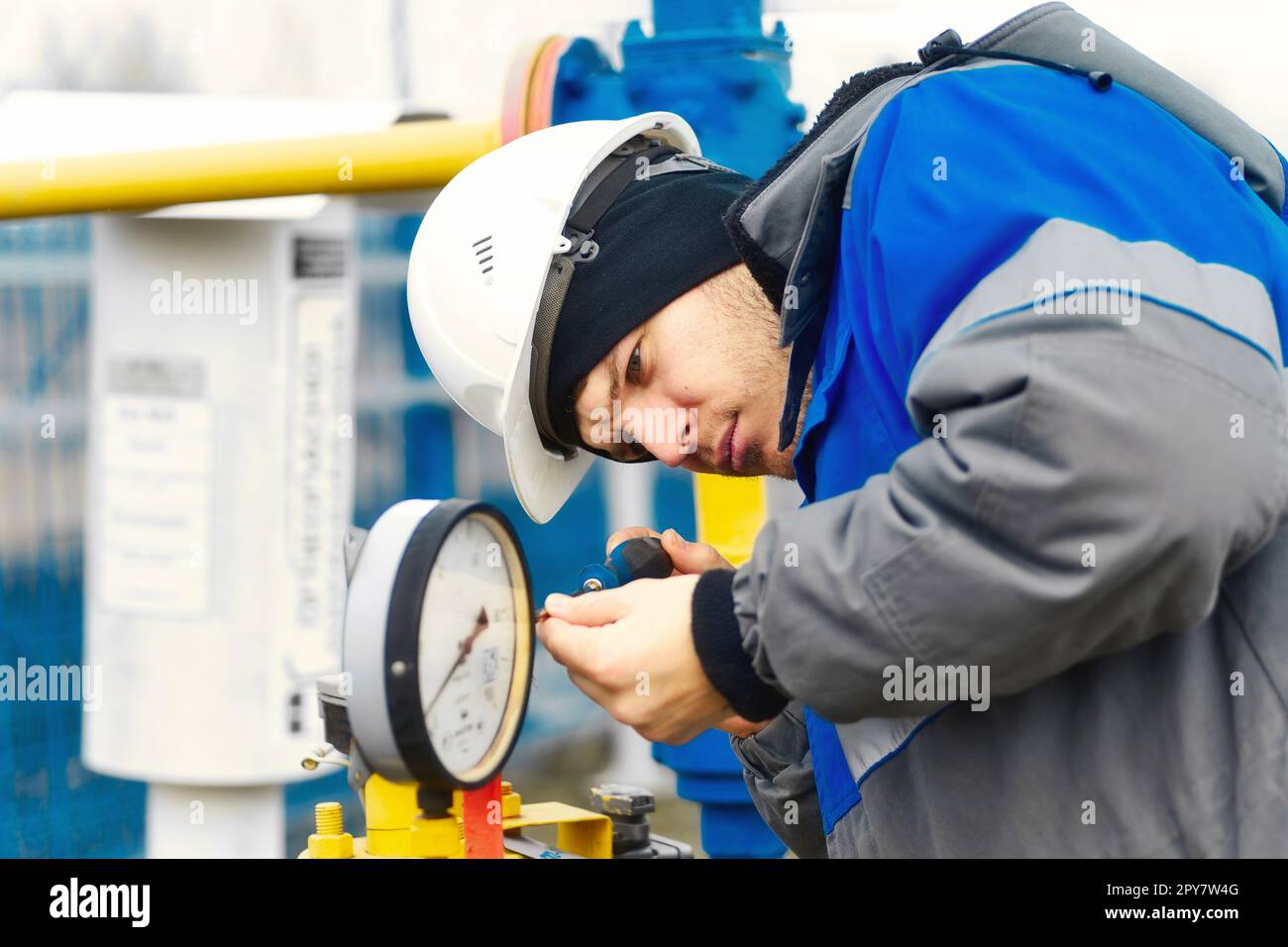 Mechanic of instrumentation and automation carefully inspects gas
