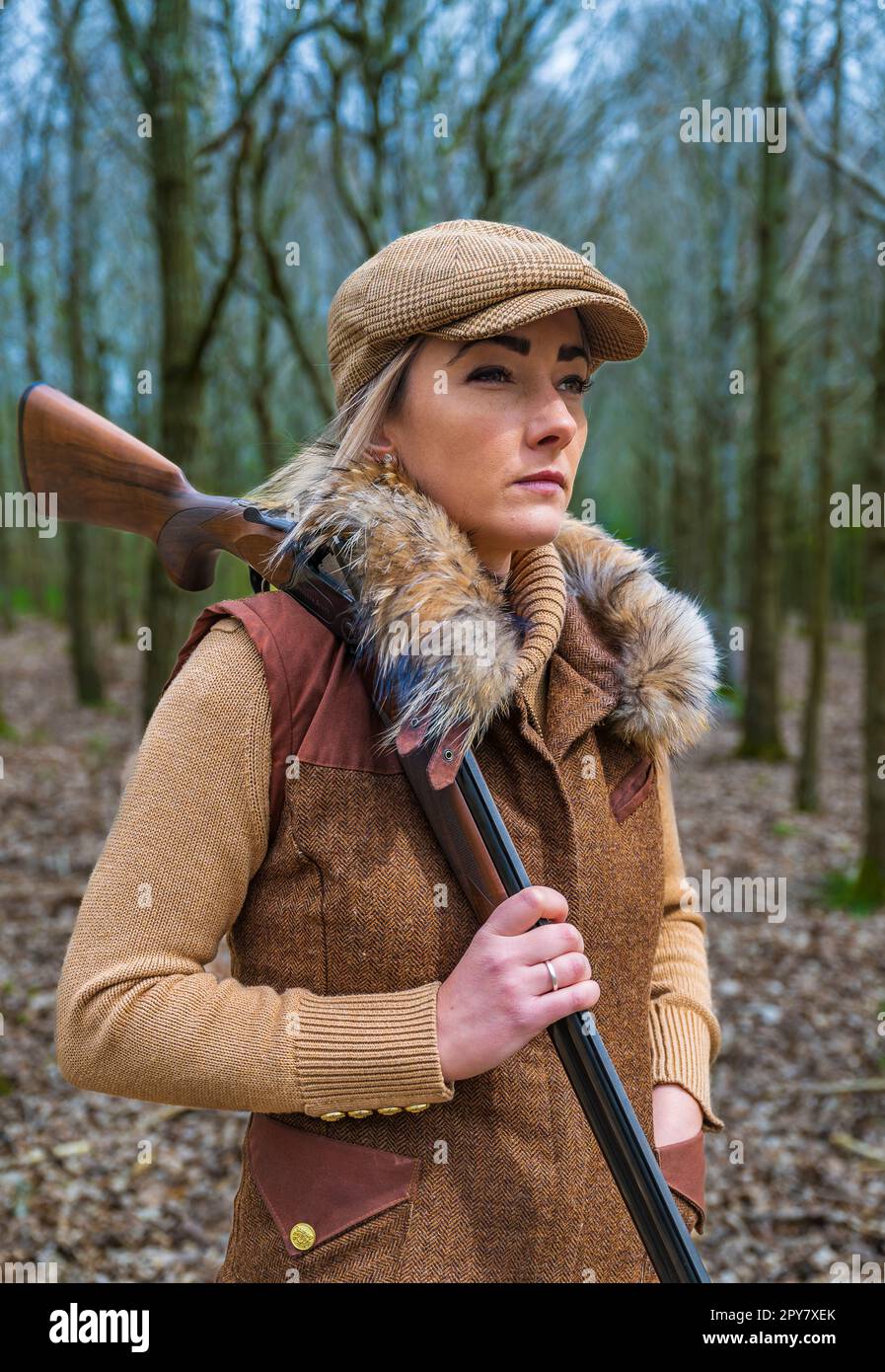 A thirty plus year old woman shooting in woodlands in the late spring with a shotgun preparing to shoot pigeons Stock Photo