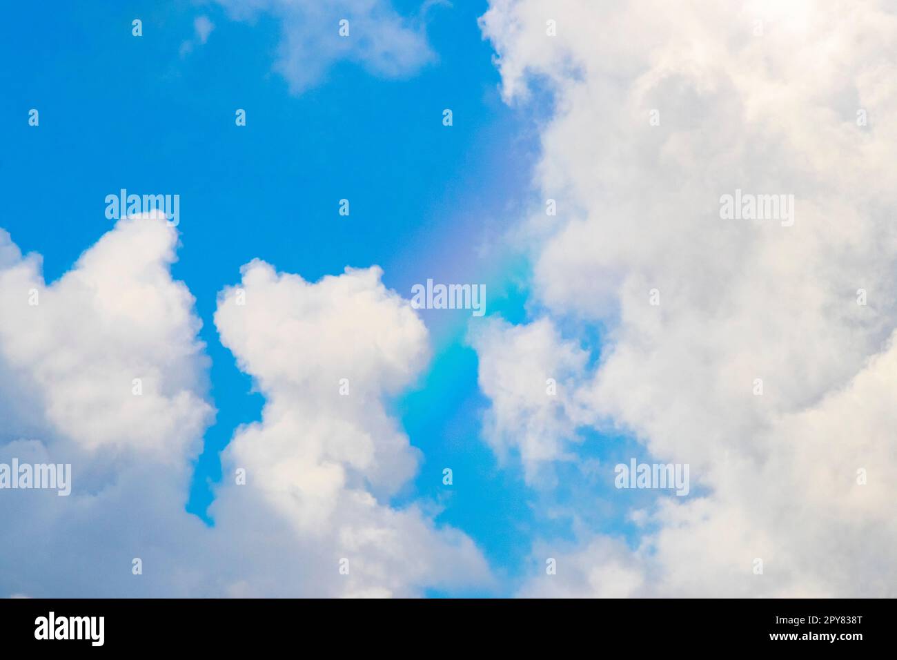 Beautiful and rare rainbow in cloudy sky blue background Mexico. Stock Photo