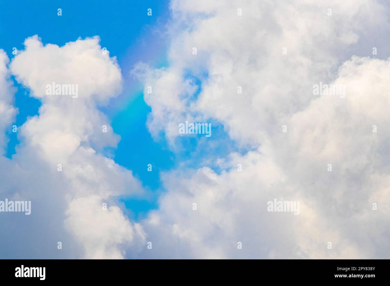 Beautiful and rare rainbow in cloudy sky blue background Mexico. Stock Photo