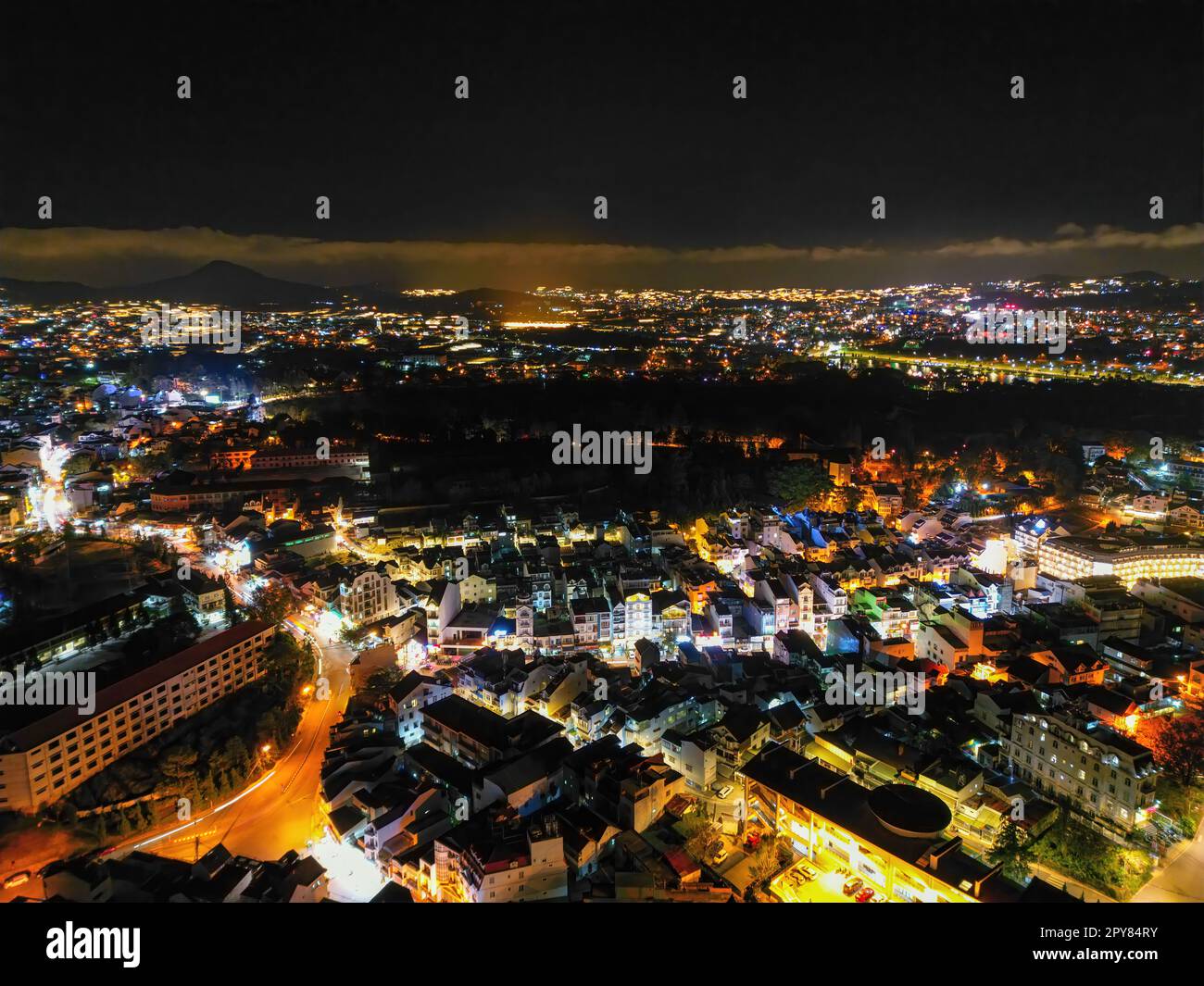 Illuminated Night View of Da Lat City, Vietnam: A Captivating Display of City Lights against the Dark Starry Sky Stock Photo
