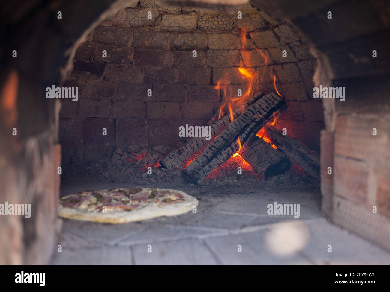 Cooking real pizza in a brick oven. Wood and fire are burning in the stove Stock Photo Alamy