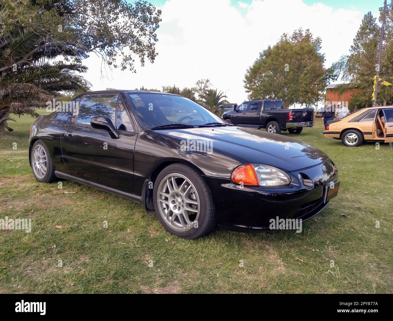 Old 1990s black Honda CRX del Sol two seater targa top on the lawn