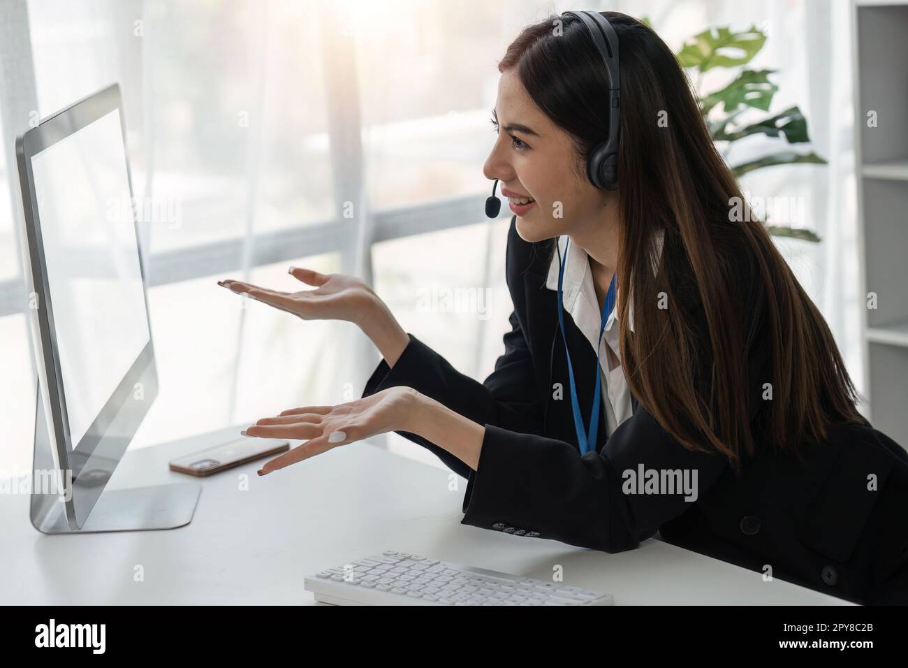 female operator working on computer and while talking with clients. Concept relevant to both call centers and customer service offices Stock Photo