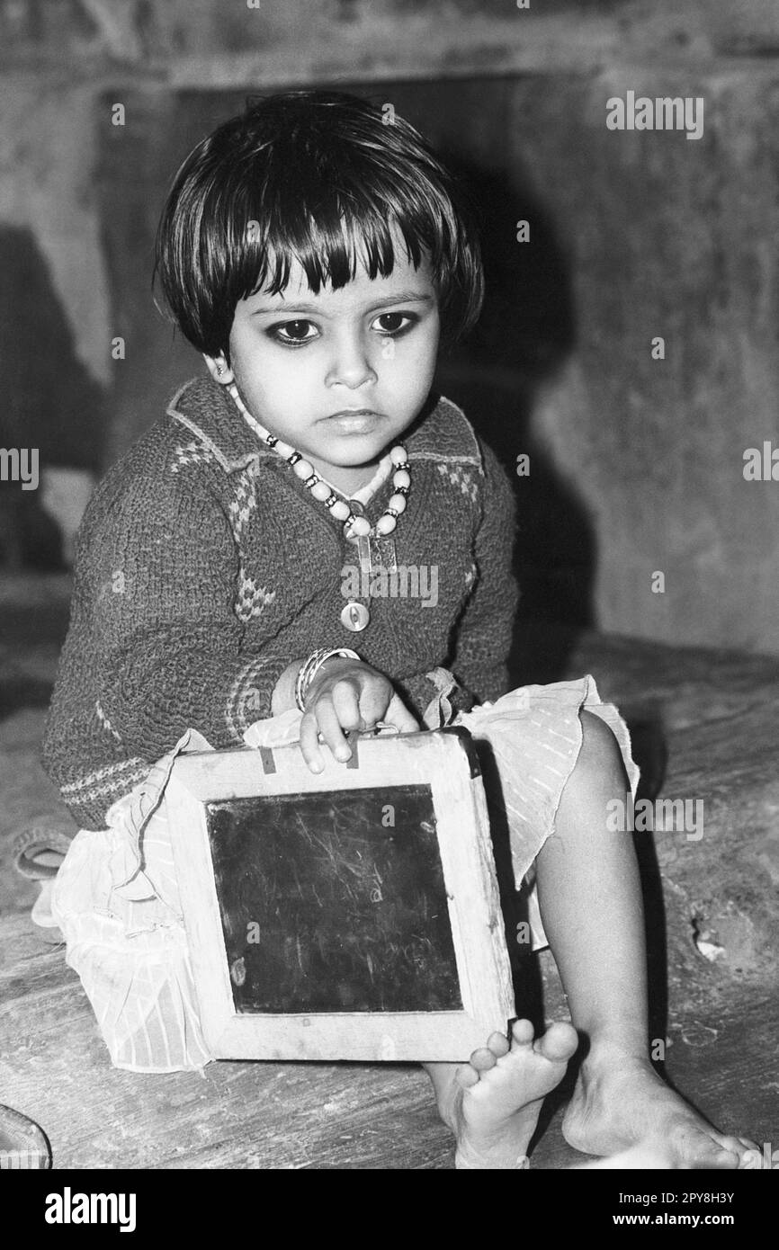 Indian old vintage 1980s black and white bollywood cinema hindi movie film actor, India, child actor with slate, India Stock Photo