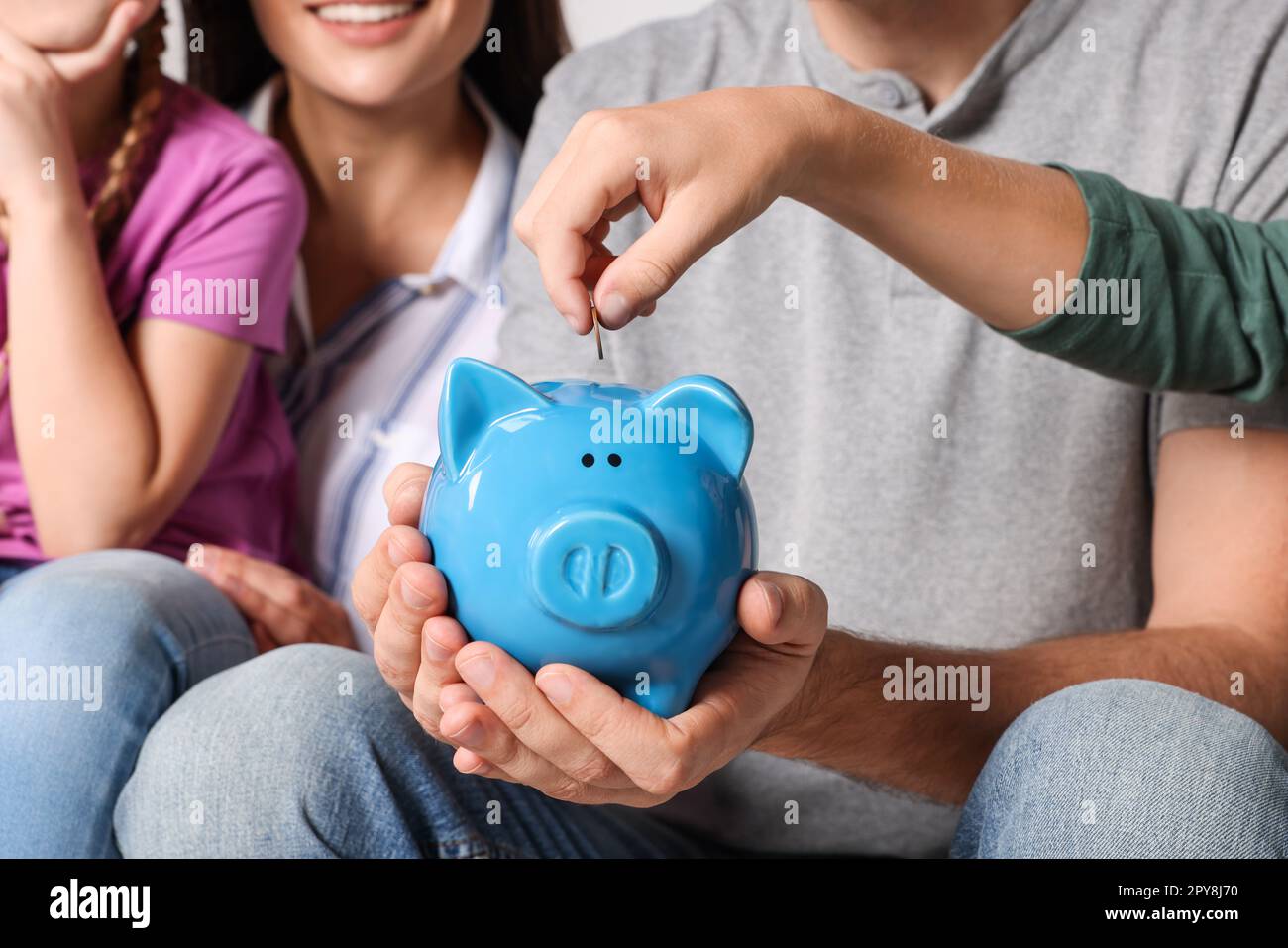 Happy family with coin and piggy bank, closeup Stock Photo - Alamy