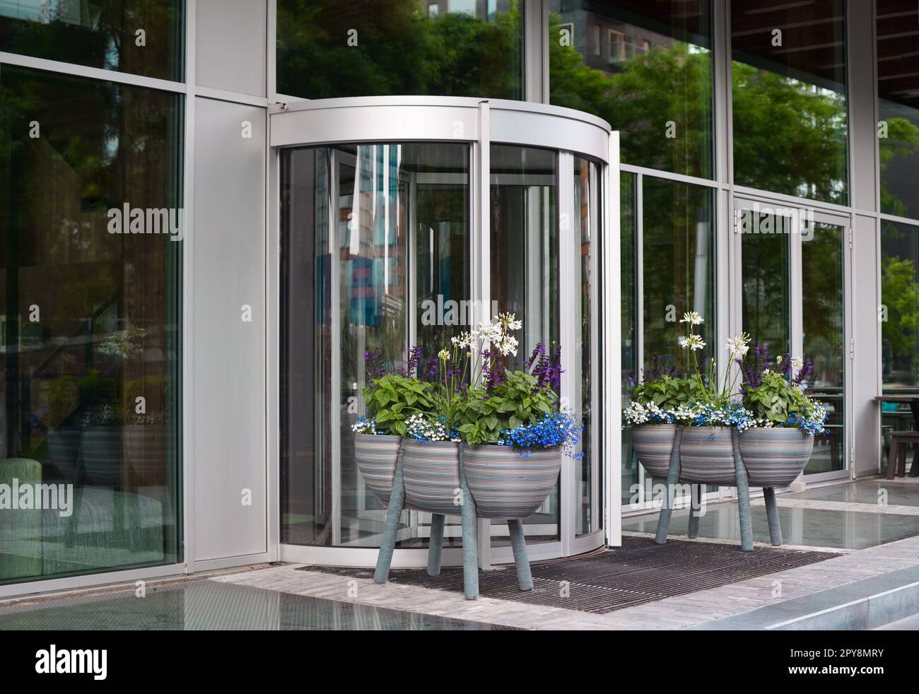 Potted flowers near entrance to beautiful modern building Stock Photo