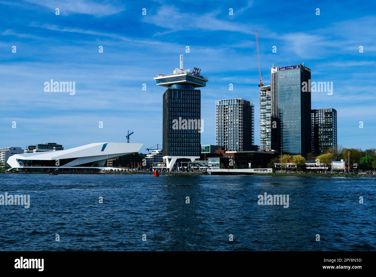 Amsterdam waterfront cityscape by the IJ with the A'DAM Lookout tower (centre) and EYE Film Instituut cultural centre (left). Stock Photo