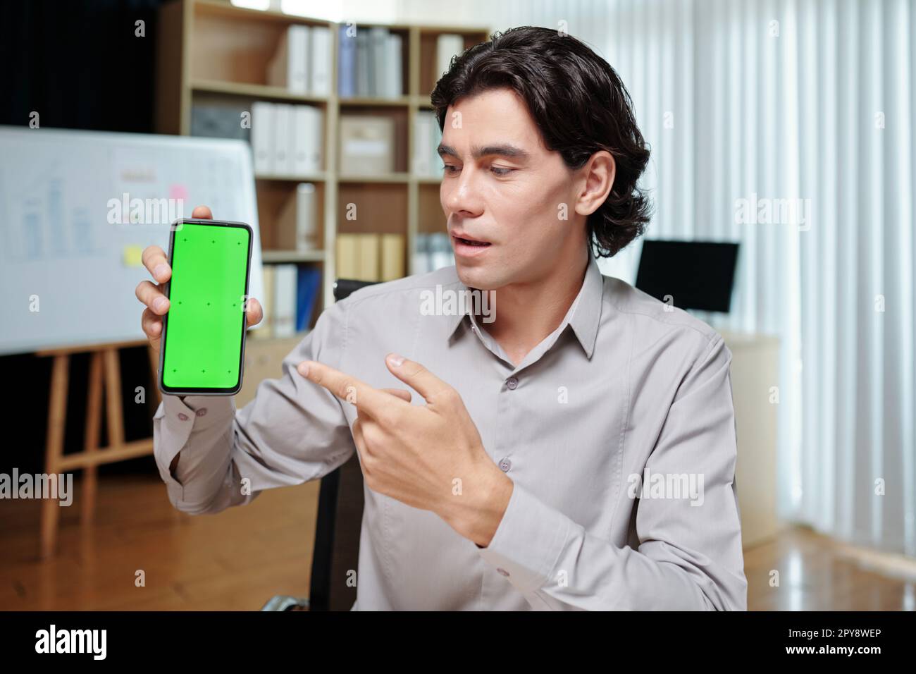 Startupper showing smartphone with application he developed on screen Stock Photo