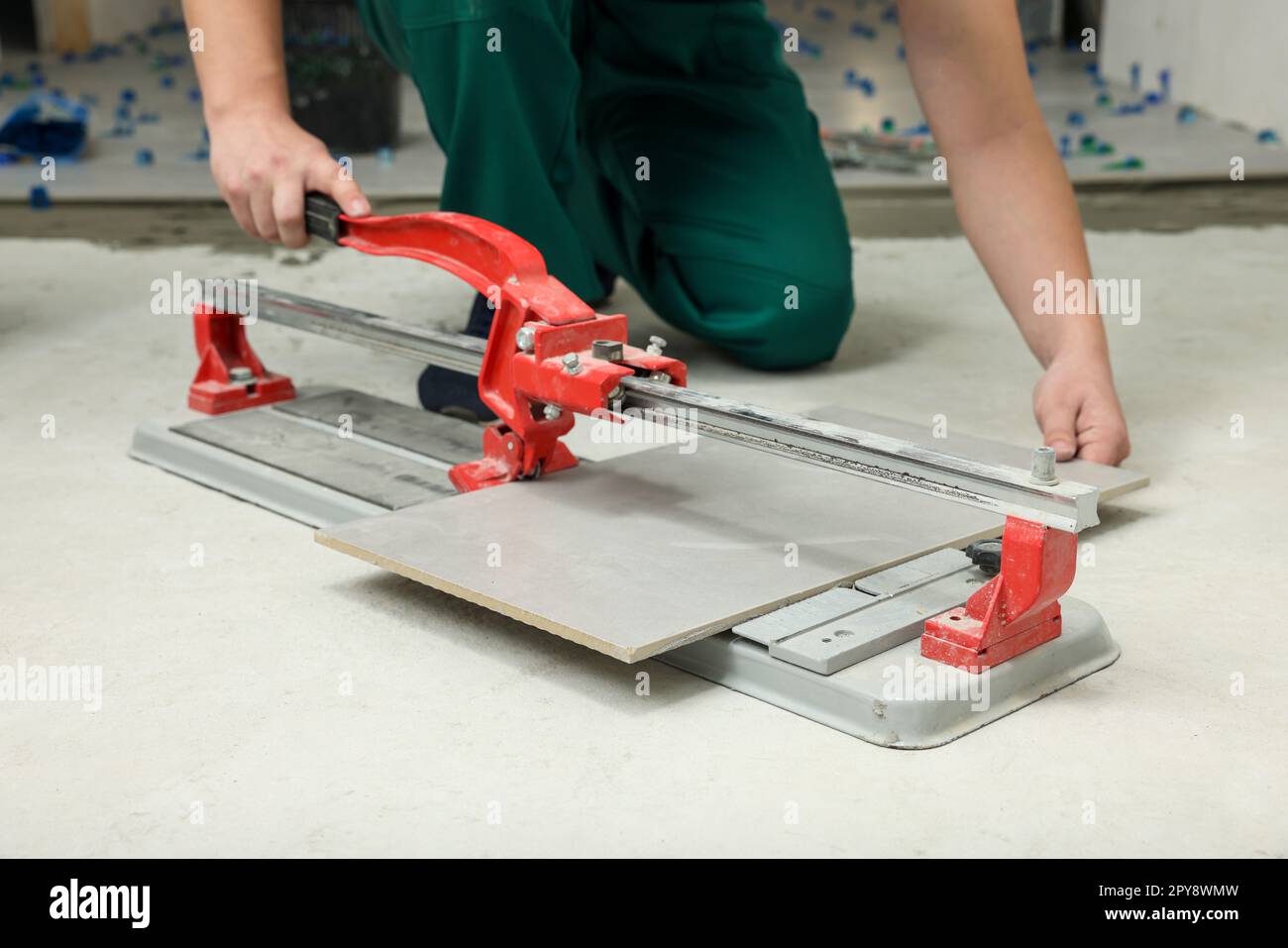 Worker using manual tile cutter on floor, closeup Stock Photo