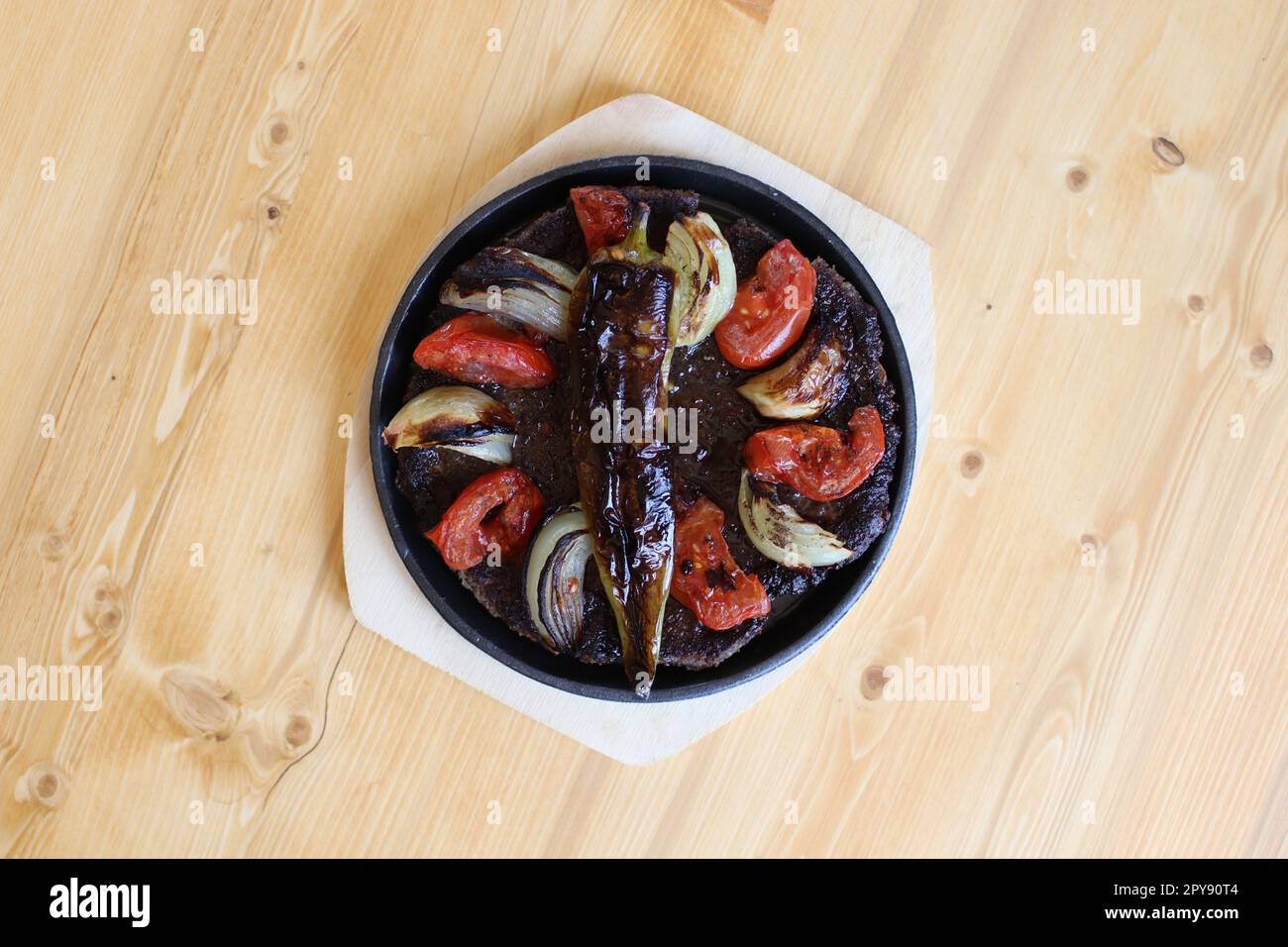 A white bowl overflowing with a healthy and nutritious meal on a wooden table Stock Photo
