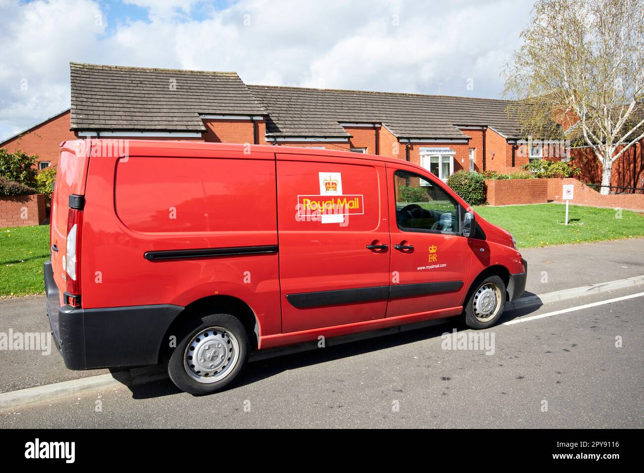 royal mail postal delivery van parked on pavement in front of social housing south belfast northern ireland uk Stock Photo