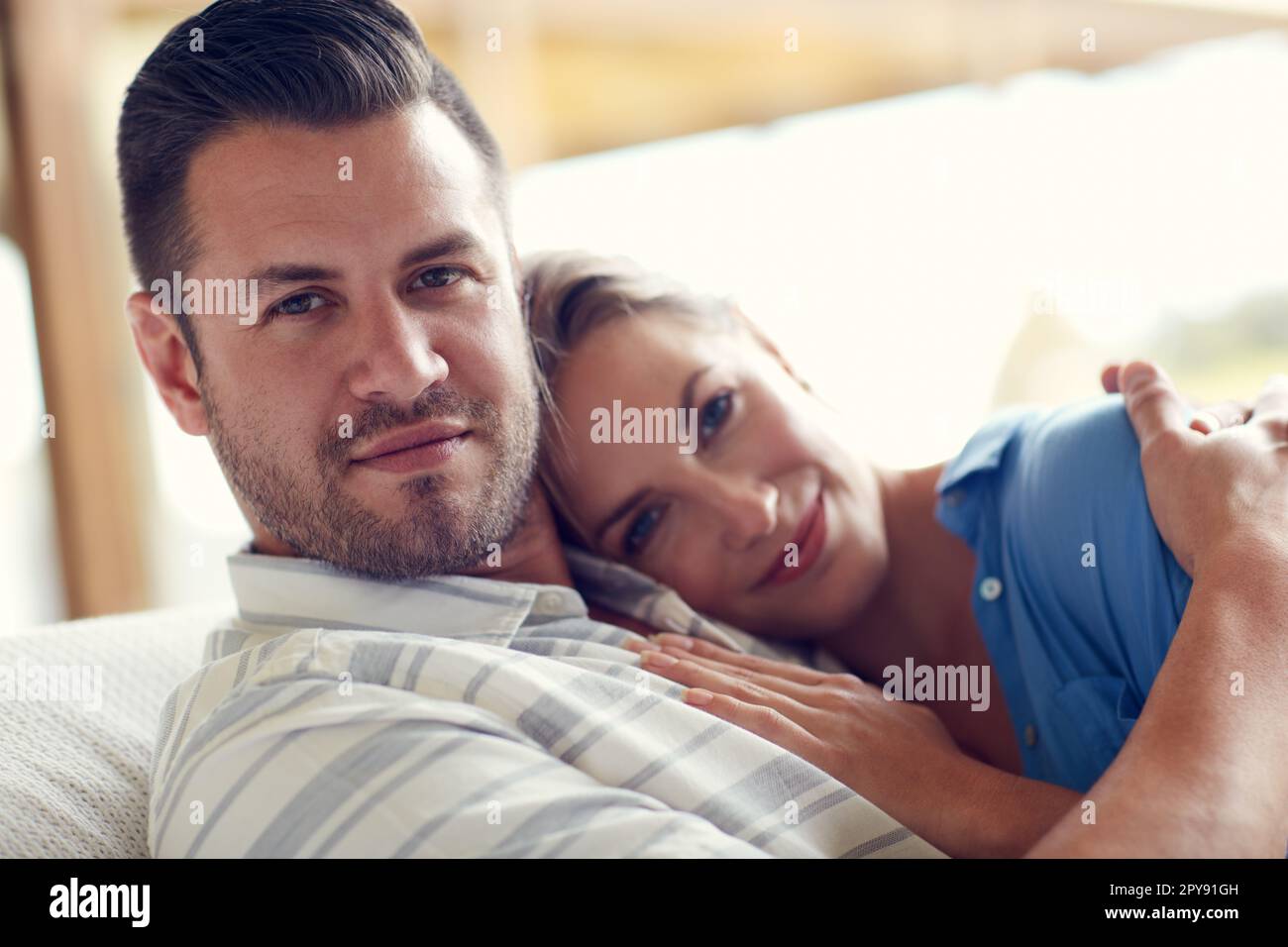 Cuddling on the couch is what we love. a young attractive wife lying on