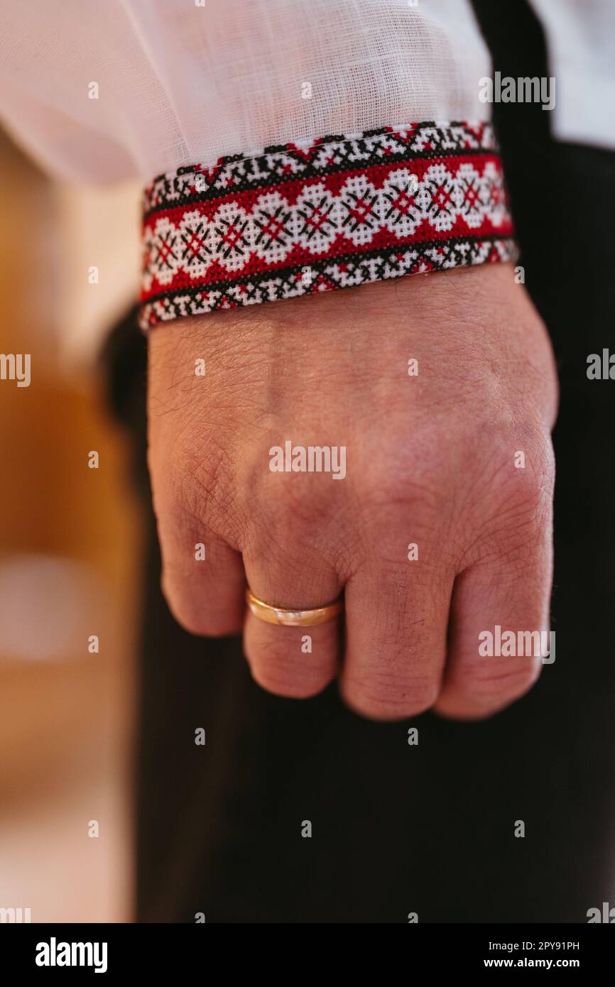 Hand of Ukrainian man with golden wedding ring on his finger in