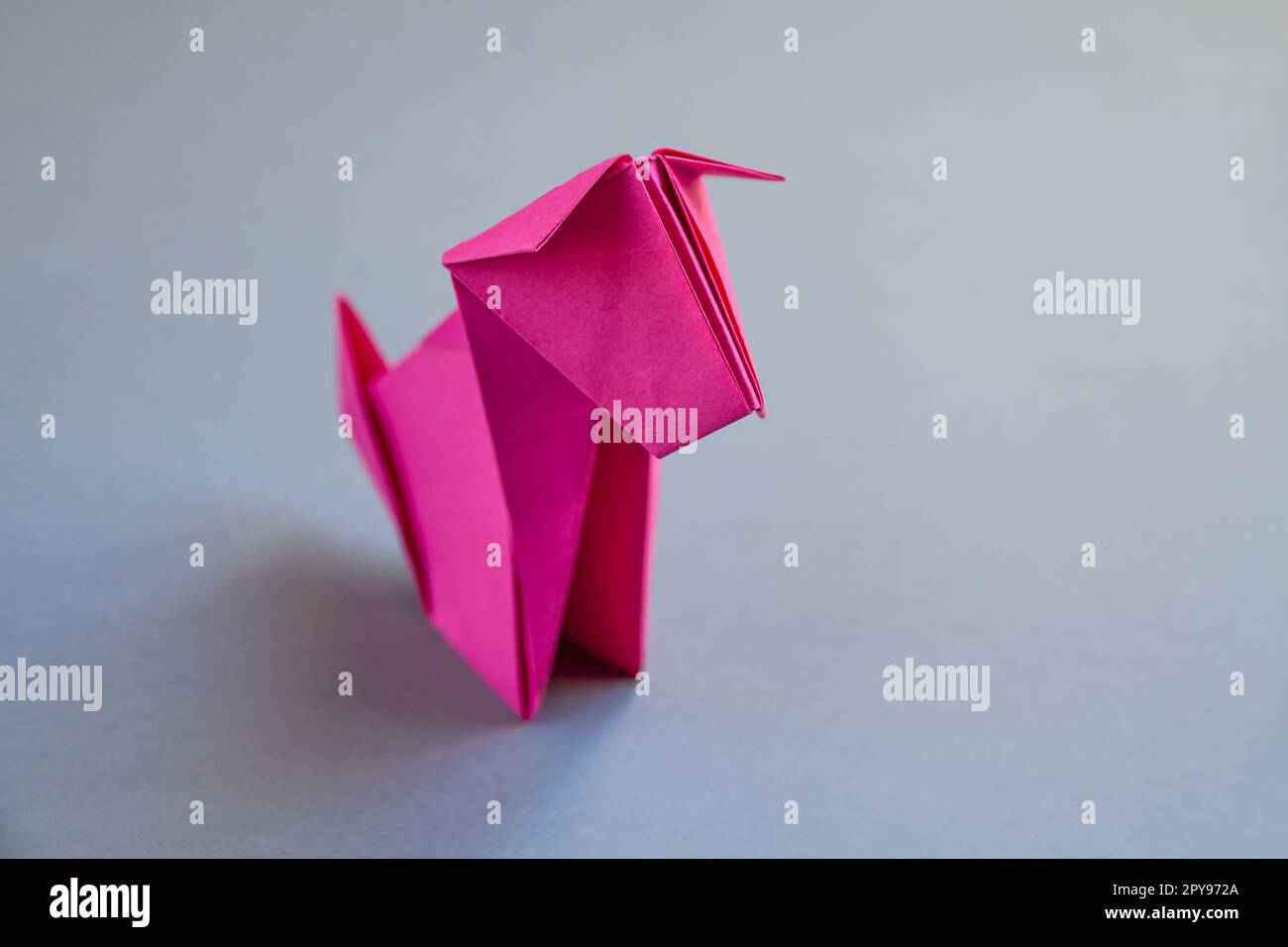 Pink paper dog origami isolated on a grey background Stock Photo