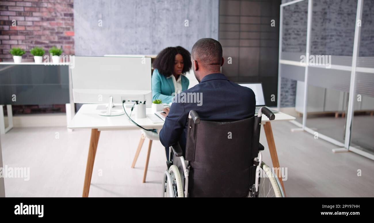 Two Young Businesspeople Working On Laptop Stock Photo