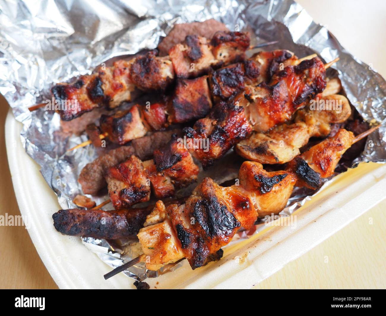 Grilled meat in disposable packaging and aluminum foil, delivered from