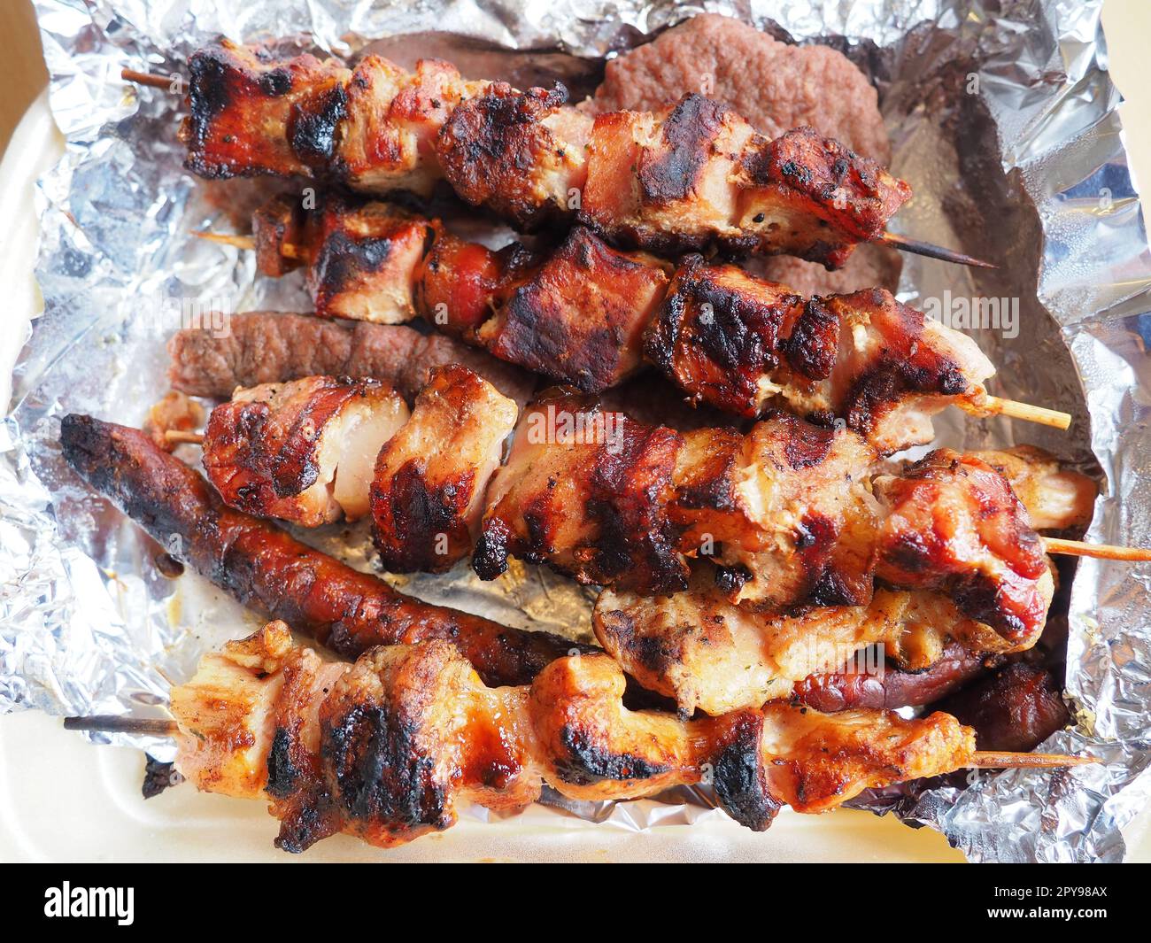 Grilled meat in disposable packaging and aluminum foil, delivered from