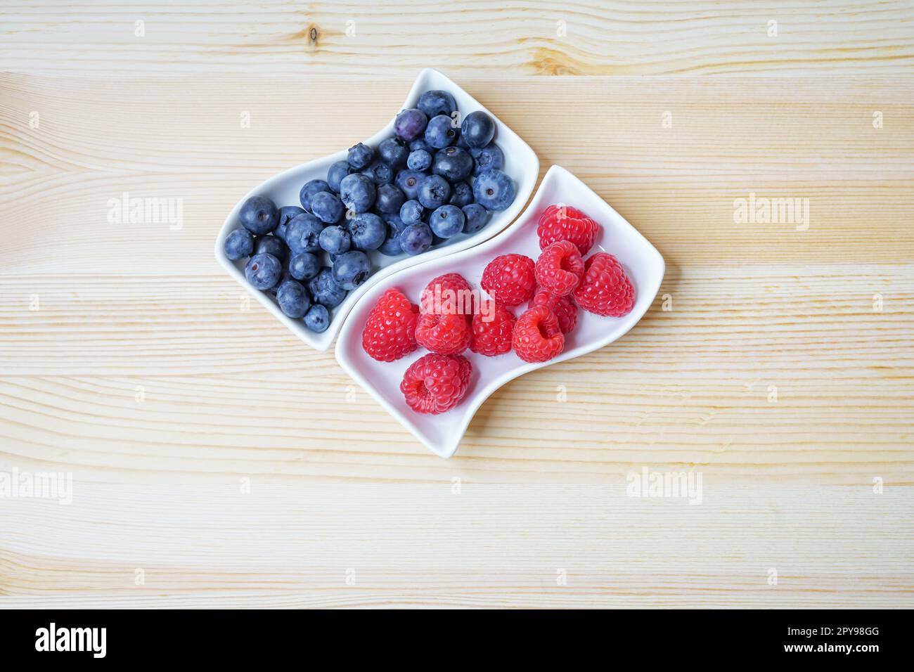 Fresh red raspberries and blueberries, still life, closeup and detail view Stock Photo
