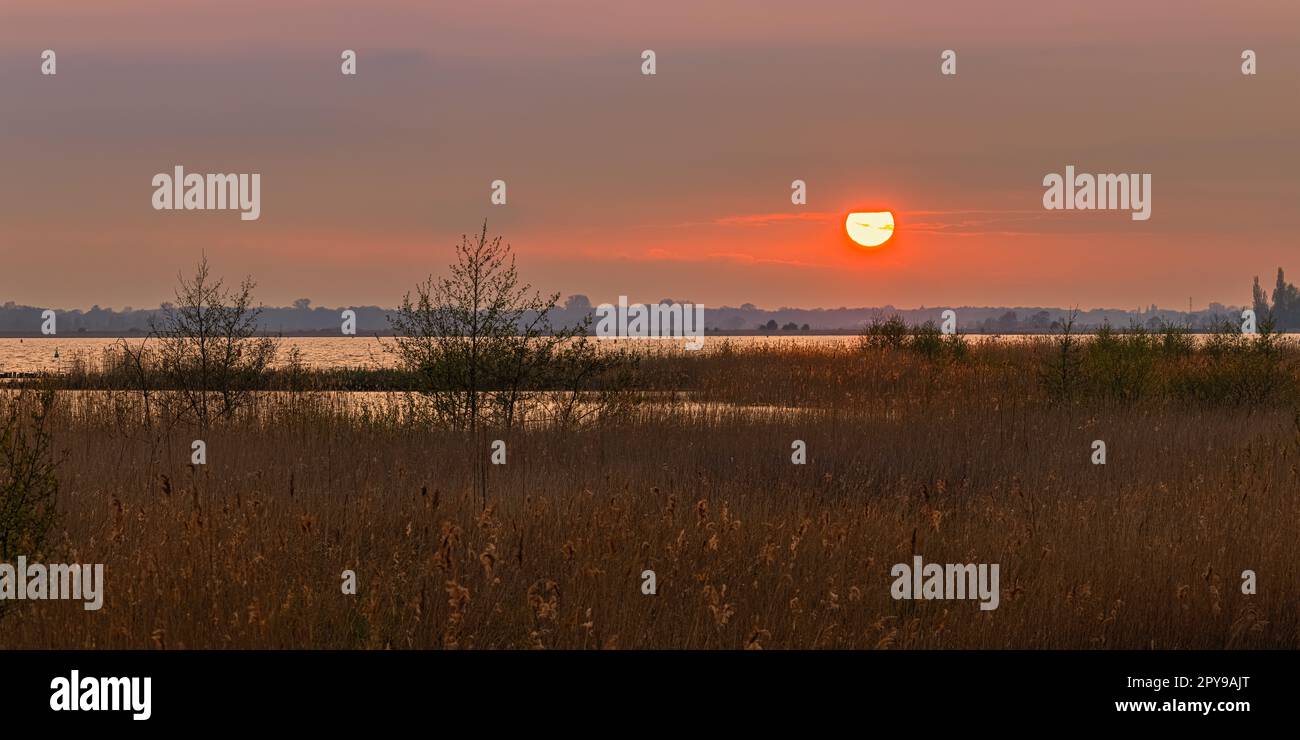 A wide 2:1 panorama image of a sunset at Zuidlaardermeer, a 540 hectares lake with an additional 120 hectares of shorelands, north of Zuidlaren and so Stock Photo